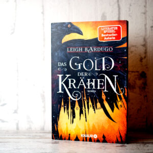 Das Gold der Krähen von Leigh Bardugo, Buch stehend vor weißem Hintergund