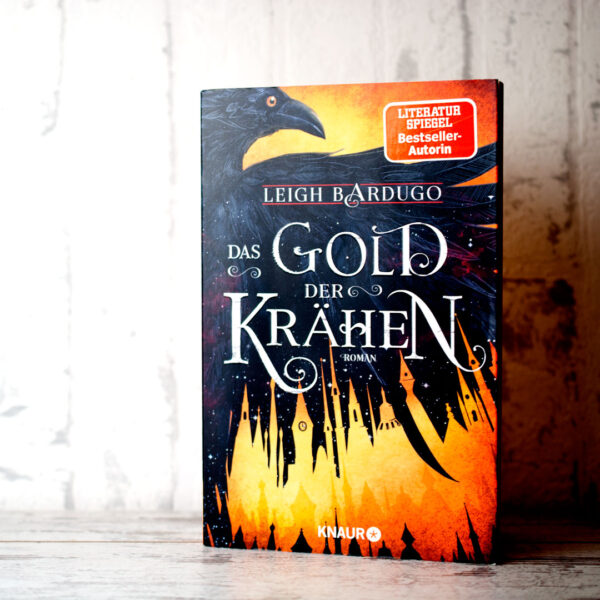 Das Gold der Krähen von Leigh Bardugo, Buch stehend vor weißem Hintergund