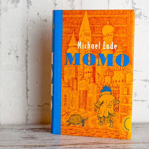 Buch: Momo von Michael Ende, aufrecht stehend vor weißem Hintergrund fotografiert