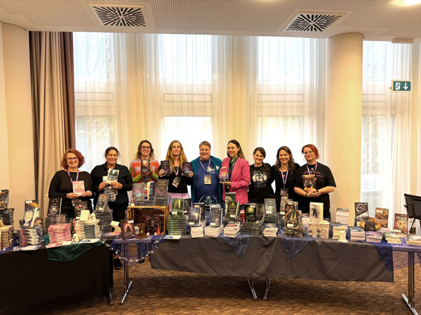 Gruppenbild Autorinnen des Hybrid Verlags und Verleger Robby, v.l.n.r: Ava Cooper, Katy Michels, Stephanie Guckenmus, Emilia La Forge, Robby Jünger, Jill Heinrichs, Nadine Engel, Sonja Tornefeld, J.N. Kühne