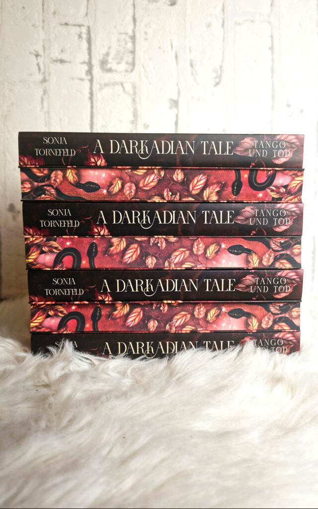 Buchstapel, der abwechselnd den Farbschnitt und den Buchrücken des Buches "A Darkadian Tale - Tango und Tod" zeigt
