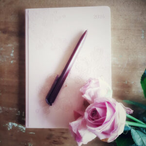 Blogtitelbild zeigt ein Notizbuch, Stift und Rose von oben fotografiert; Schmuckbild