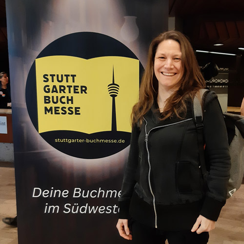 Fantasyautorin Sonja Tornefeld steht vor einem Roll-Up der Stuttgarter Buchmesse. Titelbild Blogbeitrag.